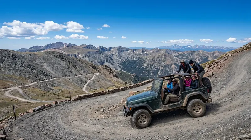 Open-top 4x4 jeep with passengers climbing the Pikes Peak Highway switchbacks above treeline